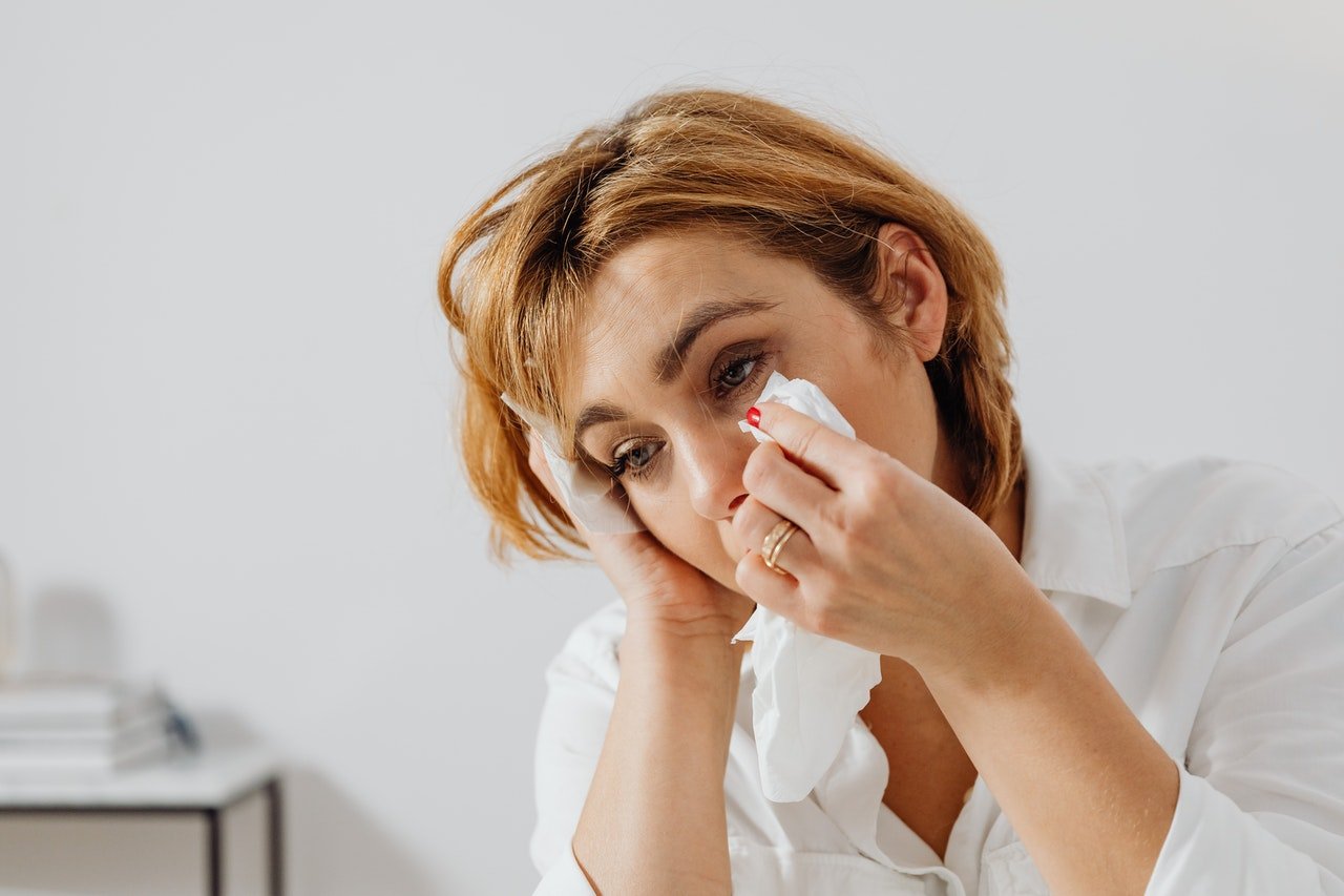 A woman wiping her tears | Source: Unsplash