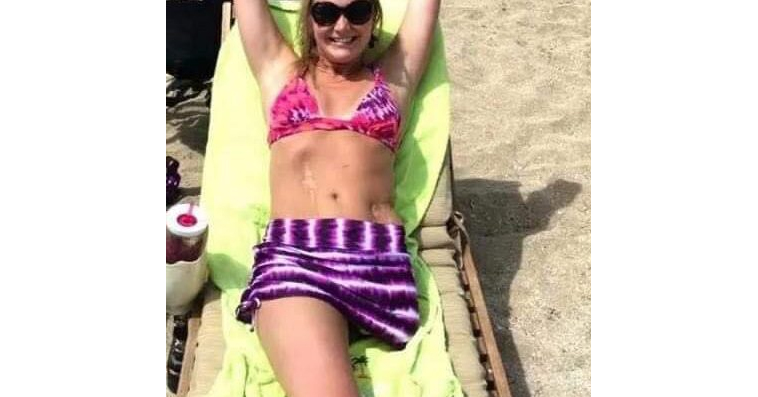 Her photo wearing a bikini on the beach is being shared bu thousands and when the camera zooms out we understand why